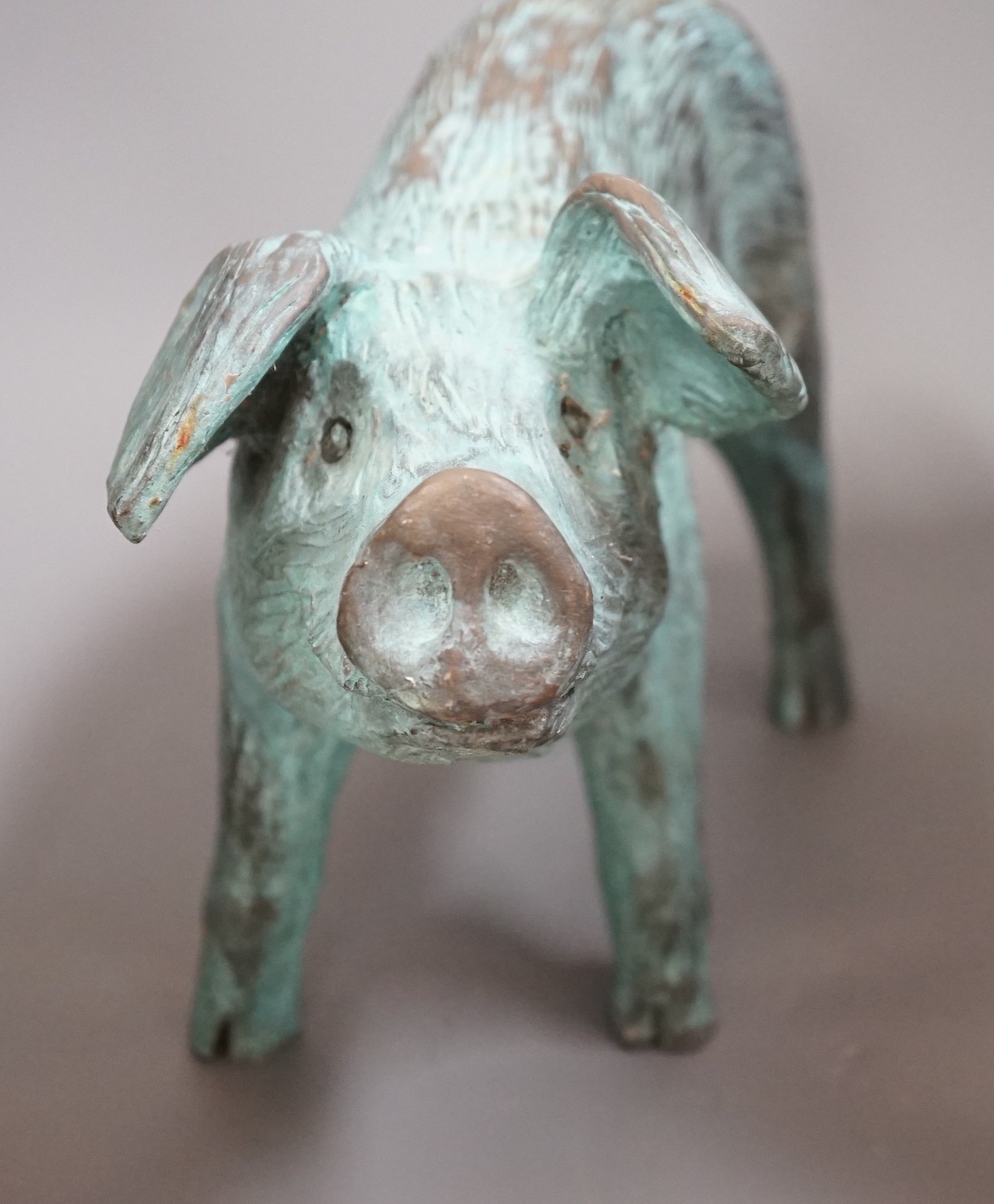 A cold cast resin bronze pig initialled 'JP', 40cm wide